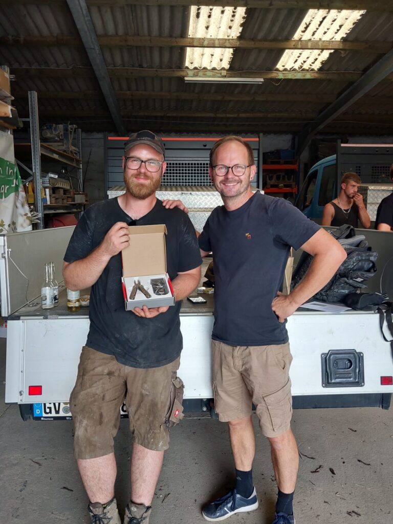 Oliver Füchtenbusch (links) gratuliert Maximilian Kirschke (rechts) zum bestandenen Meister. Sie schauen lächelnd in die Kamera.