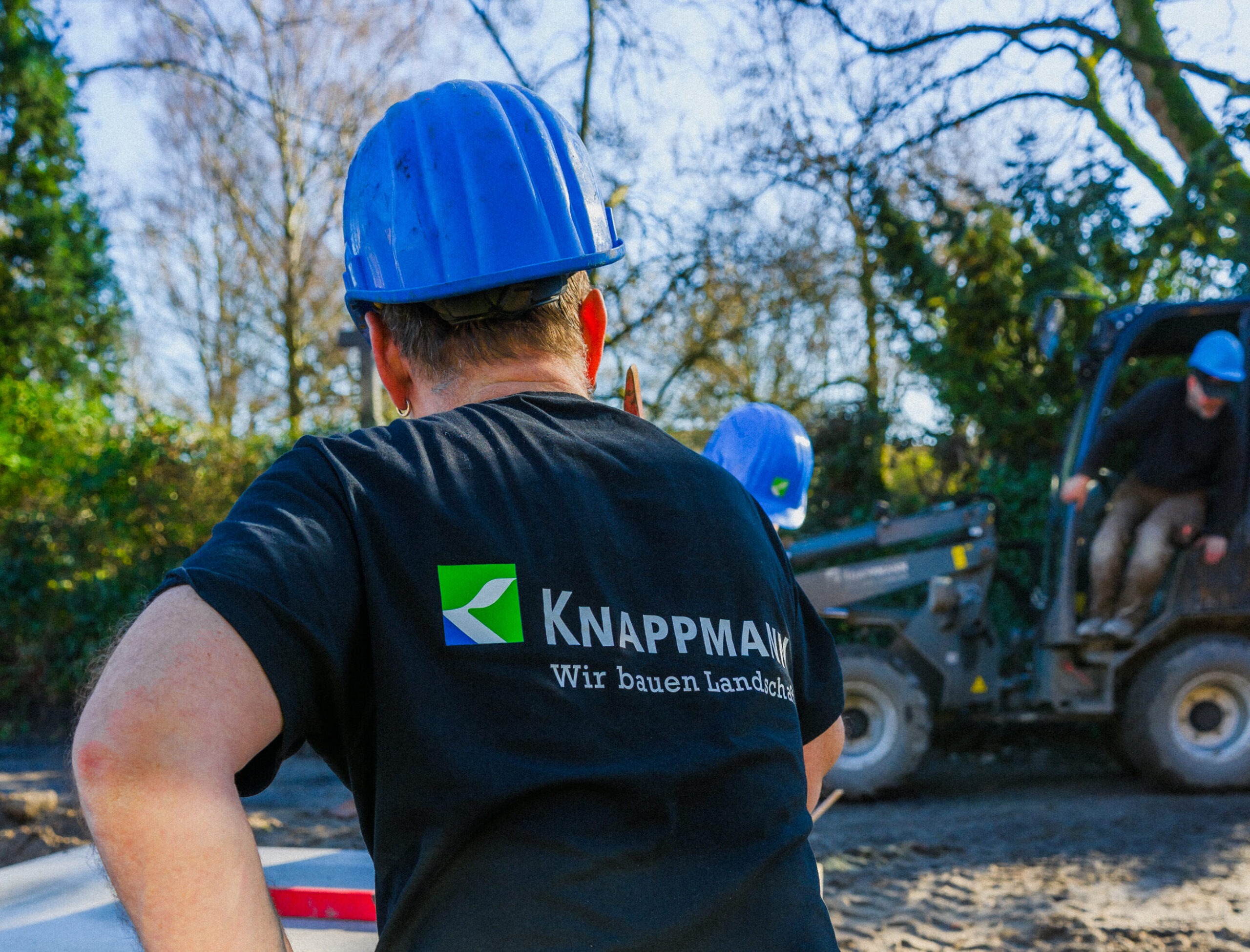 Mitarbeiter auf der Baustelle trägt einen Helm.