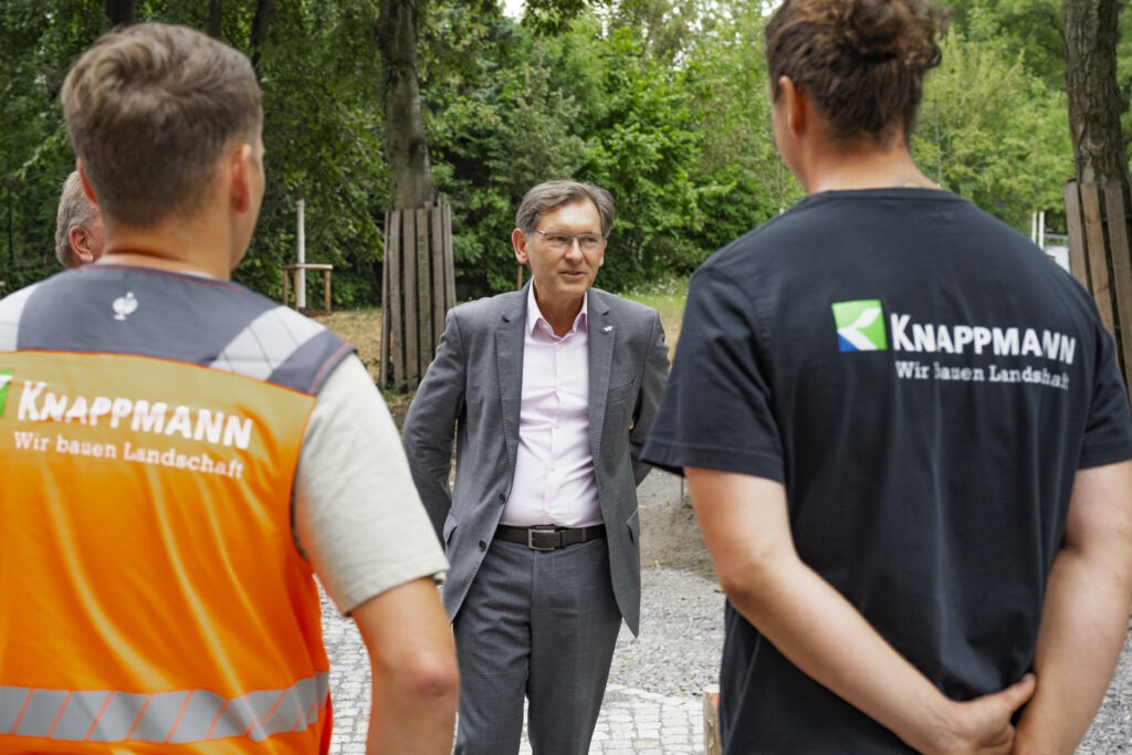 Über die Schultern von Knappmann-Mitarbeitern ist Oberbürgermeister Dr. Frank Dudda zu sehen.