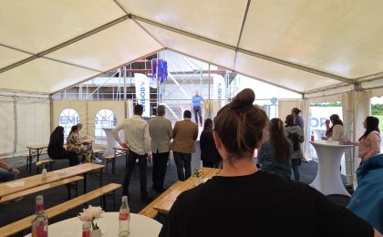Freiraumplaner Jens Tanko von KNAPPMANN ONE ist von hinten zu sehen beim Richtfest. Auf seinem T-Shirt ist das Logo des Unternehmens zu sehen.